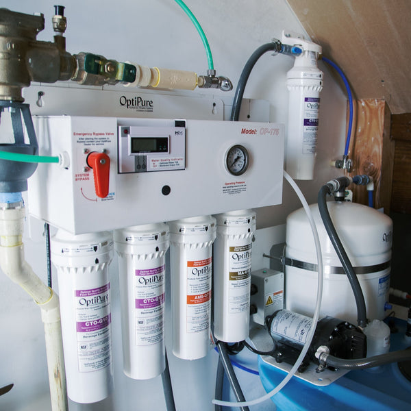 Water filtration system with multiple filters and a control panel on a wooden surface.